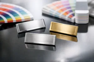 Showing how Pantone color guides are used to match colors on metal tags, emphasizing reflective qualities and manufacturing context.