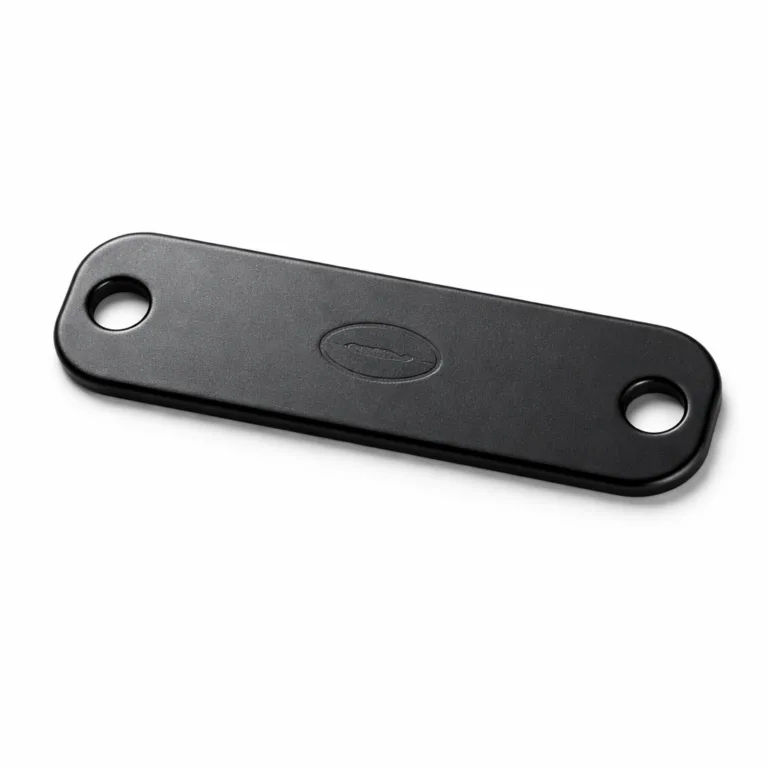 A sleek bracelet tag made from anodized aluminum with a matte black finish. Features rounded corners, single holes at both ends for easy bracelet attachment, and a blank, softly embossed emblem for a modern minimalist effect.