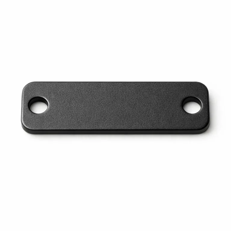 A brass bag tag plate finished in matte black nickel, featuring a refined sandblasted surface and double holes for secure sewing onto fabric or leather bags.