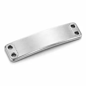 A realistic product photo of a bracelet tag plate featuring a brushed stainless steel appearance, beveled edge, and double sewing holes. The front surface displays an etched blank emblem detail, ideal for customizable jewelry applications. Studio-lit for sharp detail and commercial presentation.