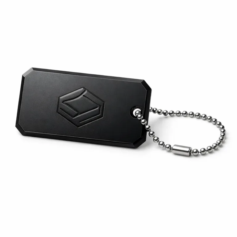 A contemporary luggage tag crafted from anodized aluminum with a rich matte black finish and beveled edges, featuring a precisely etched blank emblem and a practical ball chain for attachment.
