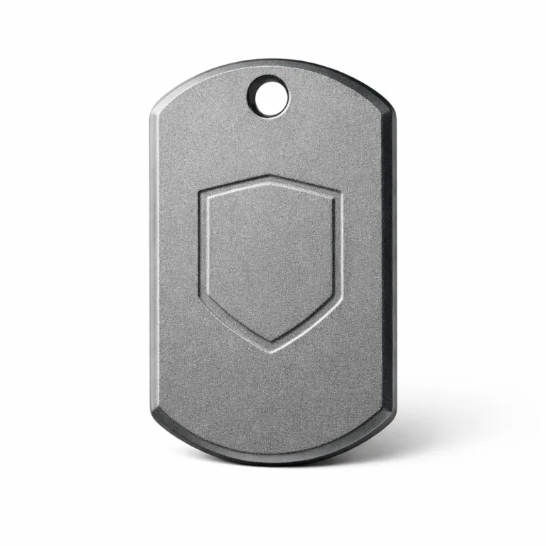 A close-up image of an anodized aluminum dog tag featuring a sandblasted matte texture, beveled edge, single hole for chain, and a debossed blank emblem, crafted for durability and lightweight use.