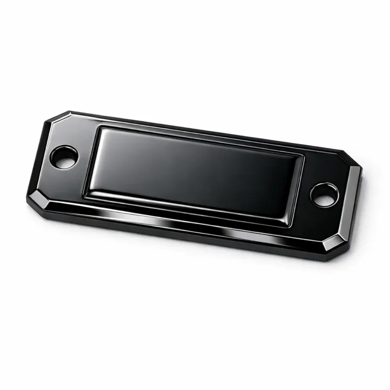 A realistic studio product photo of an embossed garment tag crafted from anodized aluminum, finished in black nickel with a mirror polished surface and beveled edges. The tag includes two small sewing holes for easy attachment.