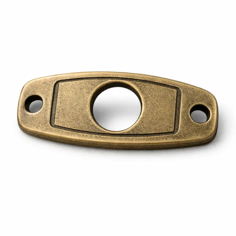 Detailed studio image showing an emergency contact bracelet tag made of antique brass with a sandblasted matte surface. It features a thick profile, single large central hole for bracelet threading, and a debossed blank emblem for subtle style.