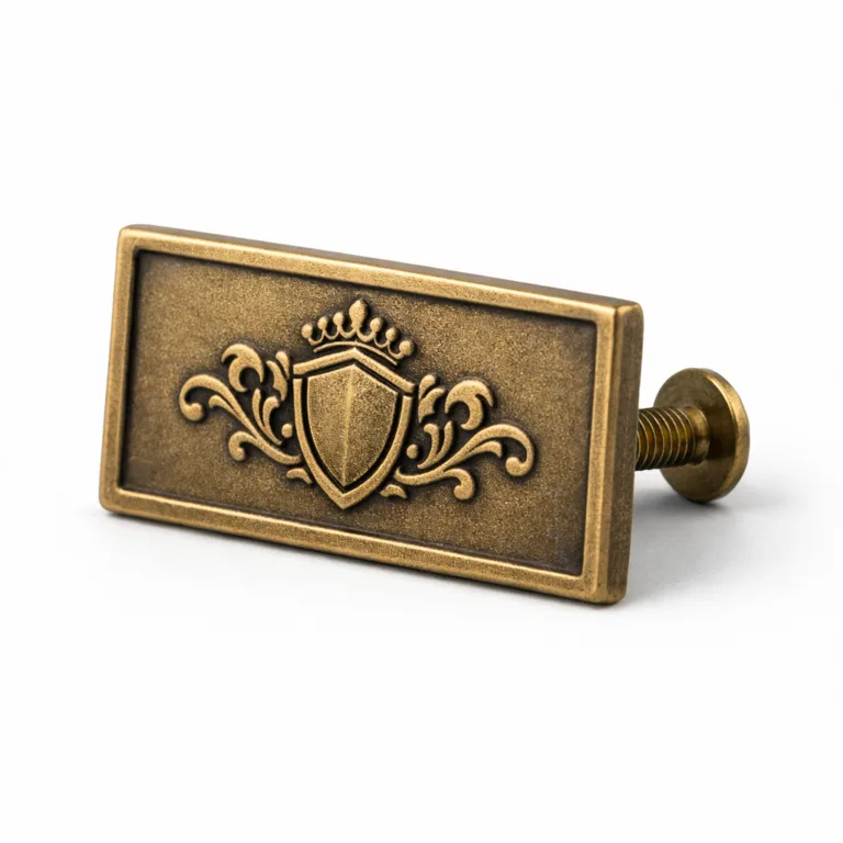 A unique antique brass finish Frame Logo Tag with a sandblasted matte texture, debossed emblem, and one screw hole backing, suitable for secure fixing to equipment or machinery.