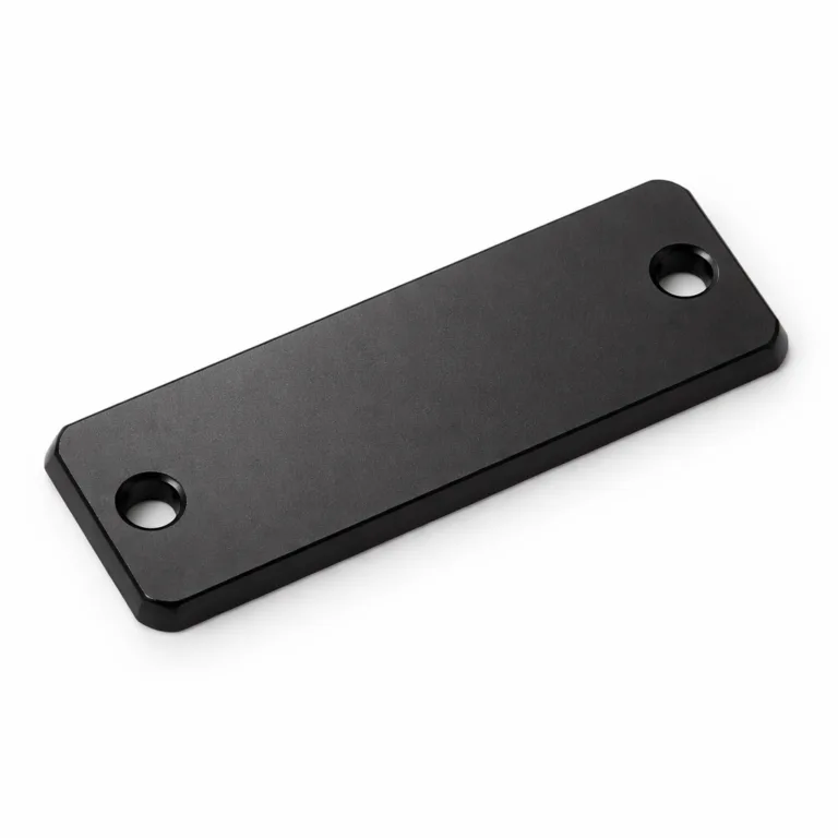 Matte black anodized aluminum garment tag in a classic rectangular shape with beveled edges and two precision-drilled stitching holes, offering a sleek, modern look suitable for contemporary fashion garments.