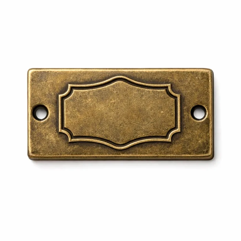 Antique brass garment tag displaying an embossed blank emblem shape on the front, with dual sewing holes for versatile garment attachment, perfect for vintage-inspired clothing brands.
