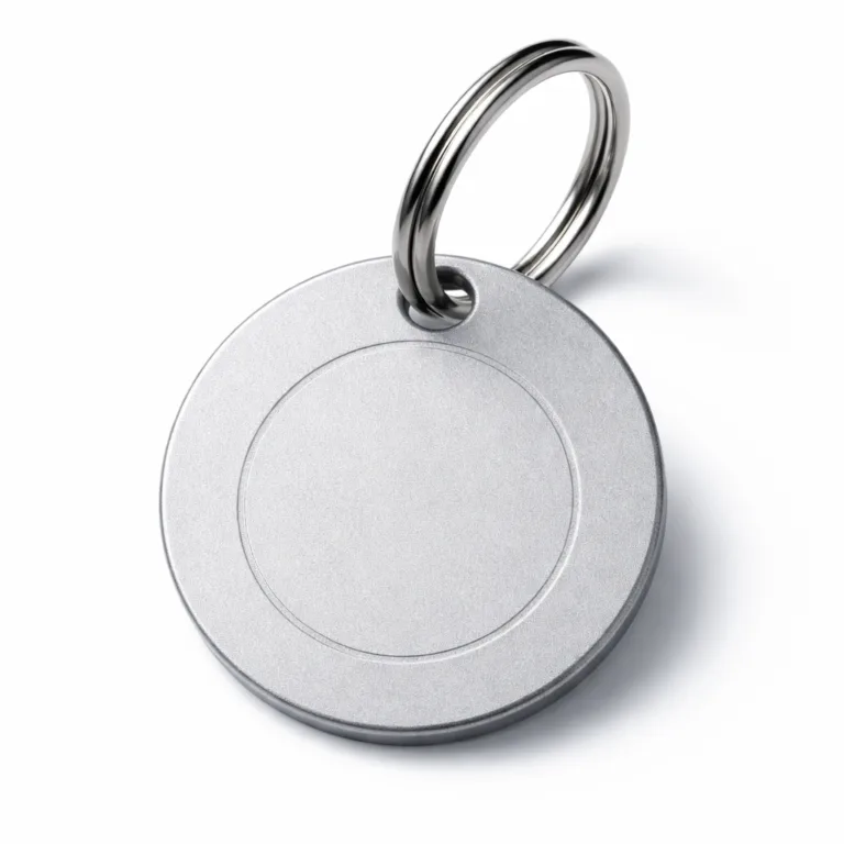 A realistic studio image of a round keychain tag crafted from sandblasted matte anodized aluminum with a debossed blank emblem, a single hole, and a split ring attachment. Lightweight and modern for everyday use.