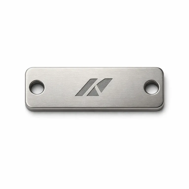 Sleek anodized aluminum logo tag with a matte nickel finish, laser engraved front for precision detailing, and single mounting holes at each end. Perfect for lightweight branding solutions.