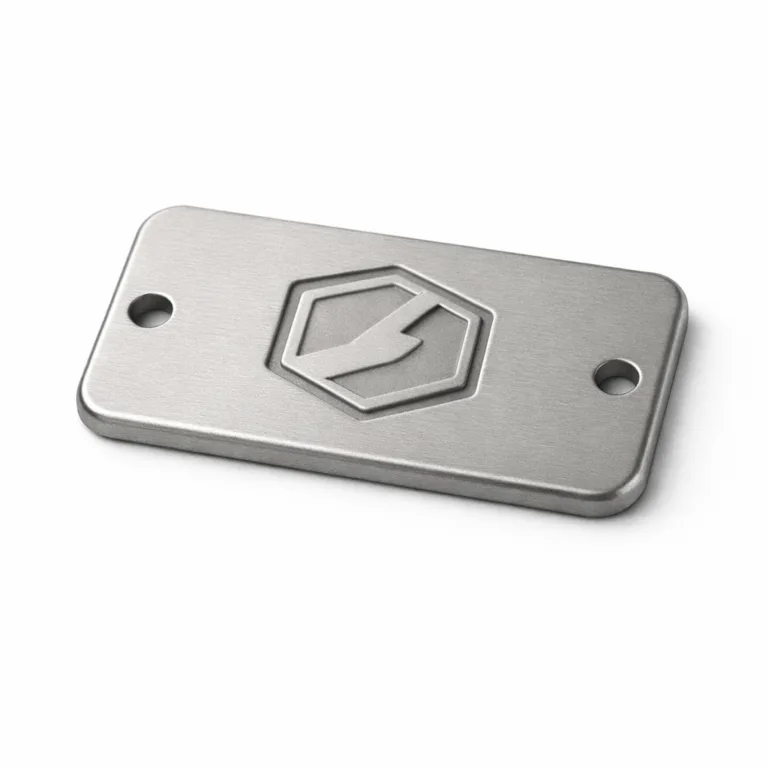 Logo tag featuring an anodized aluminum visual style, matte nickel finish, rounded corners for a soft appearance, and a debossed emblem detail without readable text—suitable for discrete high-end logo marking.