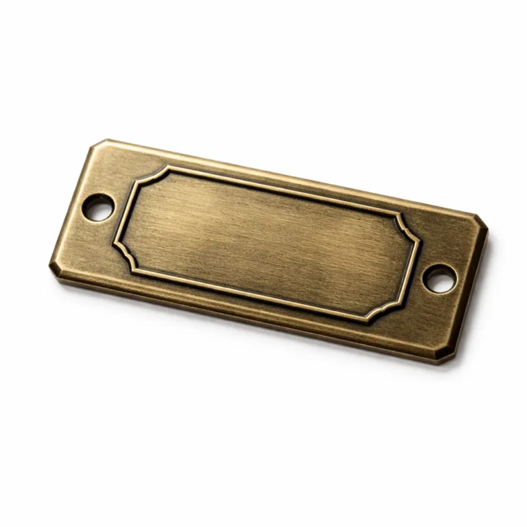A studio photo of a rectangular logo tag made of antique brass, featuring an embossed blank emblem, two precision mounting holes, and beveled edges for a classic appearance.