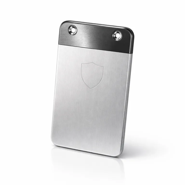 This luggage tag is manufactured from anodized aluminum with a two-tone matte and polished surface. It features rounded corners and dual rivet holes for secure mounting, with a discreet blank emblem etched on the front for added visual interest.