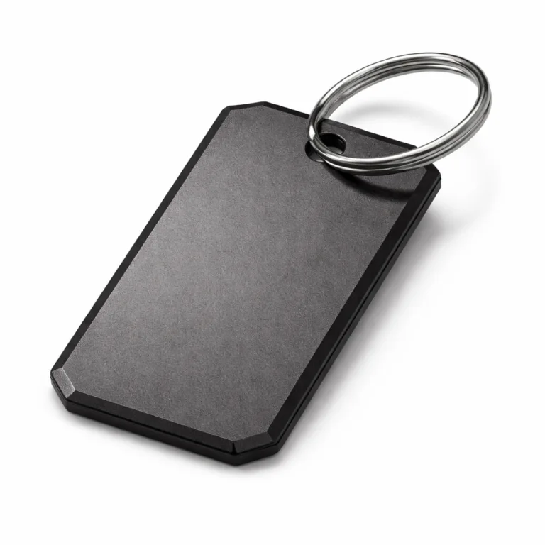 Matte black nickel plated luggage tag with an anodized aluminum appearance, featuring a sandblasted texture, chamfered edges, and a split ring for attachment. Modern style and scratch-resistant surface.
