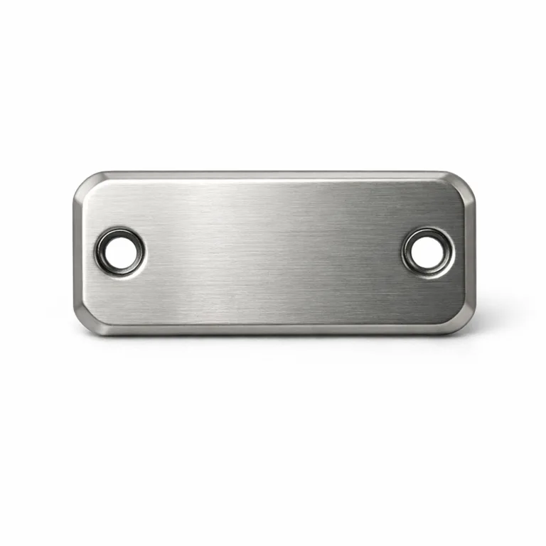 A metal logo tag crafted from brushed stainless steel with a matte nickel finish. The tag features a laser-engraved emblem, beveled edges, and double rivet holes for secure attachment.