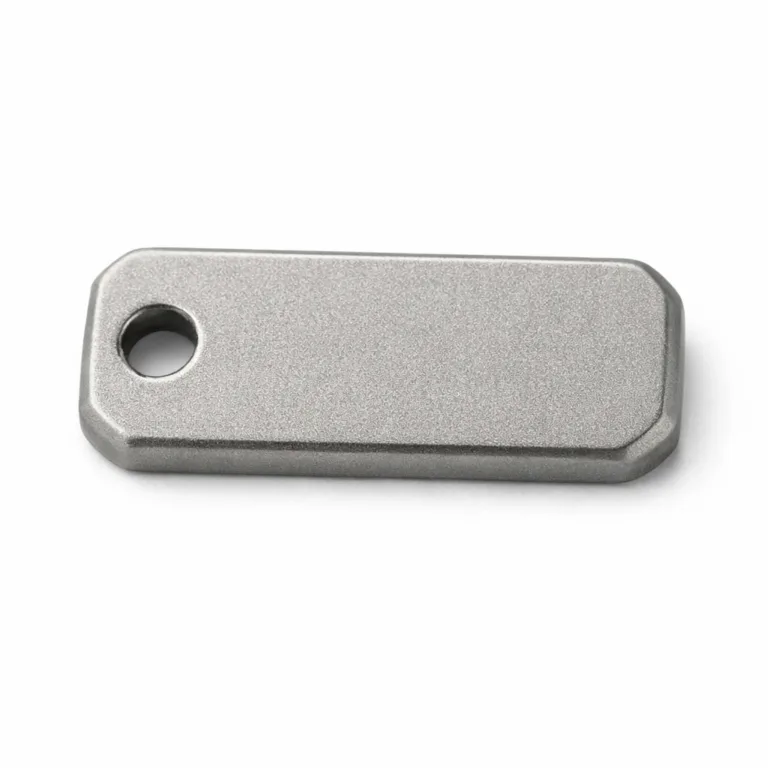 A matte nickel logo tag constructed from zinc alloy with a sandblasted matte texture, featuring a debossed emblem and a single rivet hole for mounting.