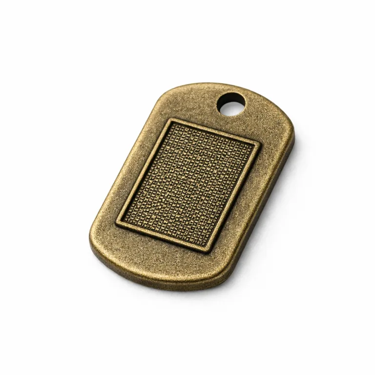 Micro-Text ID Dog Tag presented in antique brass with a sandblasted matte finish. Embossed front detail adds texture for a premium appearance, single hole supports chain or split ring.