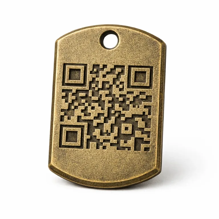 An antique brass plated zinc alloy dog tag featuring a sandblasted matte surface for a vintage appearance. The chamfered edge and subtly embossed QR code design make it both decorative and utilitarian. Includes a single hole for attachment.