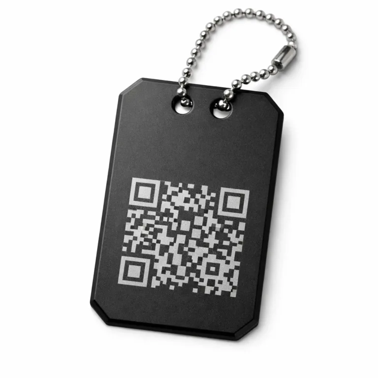 An anodized aluminum luggage tag with a sandblasted matte finish, chamfered edge design, and an etched QR code accent. Features double holes for secure ball chain attachment, perfect for modern travelers.