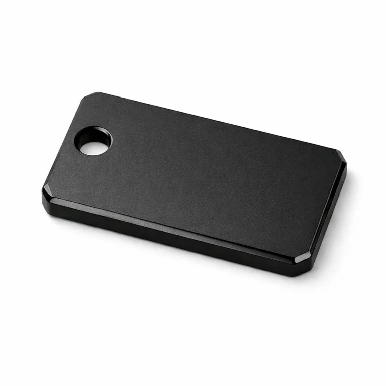A high realism image of a rectangle keychain tag made from anodized aluminum with a matte black finish. Features a beveled edge and a single hole for split ring attachment. Sleek and minimalistic design for everyday use.
