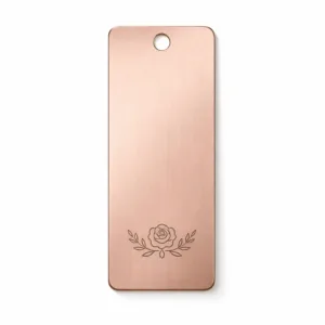 A premium stainless steel bookmark tag in brushed rose gold finish, featuring rounded corners, a single hole at the top center for ribbon attachment, and a minimalist laser engraved emblem. Perfect for elegant gifting or personal use.