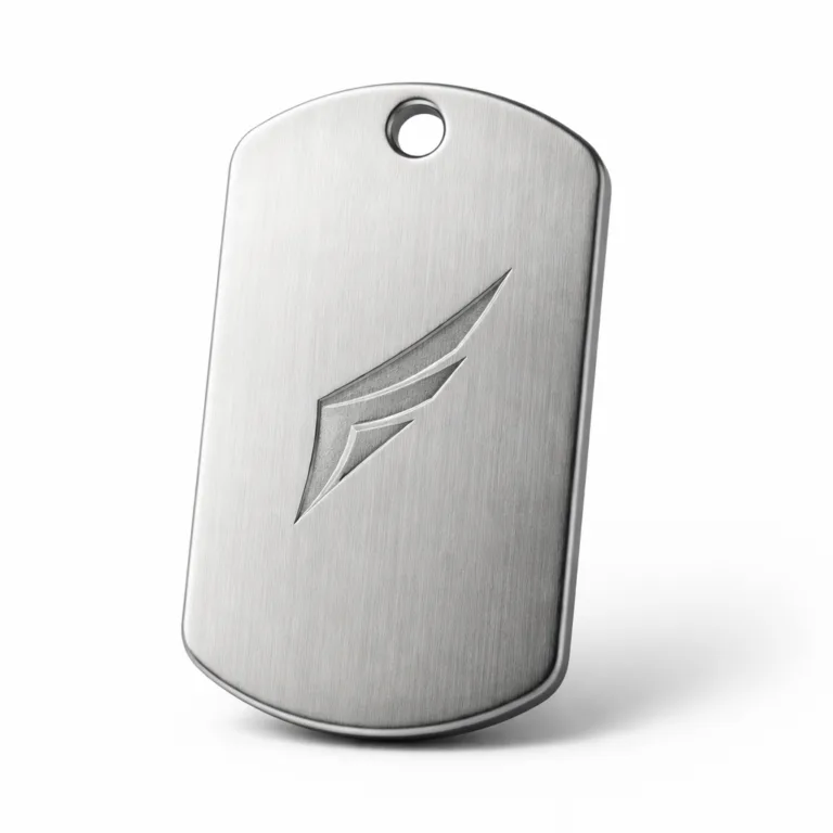 A Silent Edge dog tag manufactured from brushed stainless steel, featuring a matte finish, a single hole for chain attachment, and a subtle debossed emblem for a modern, understated appearance. Perfect for durability and style.