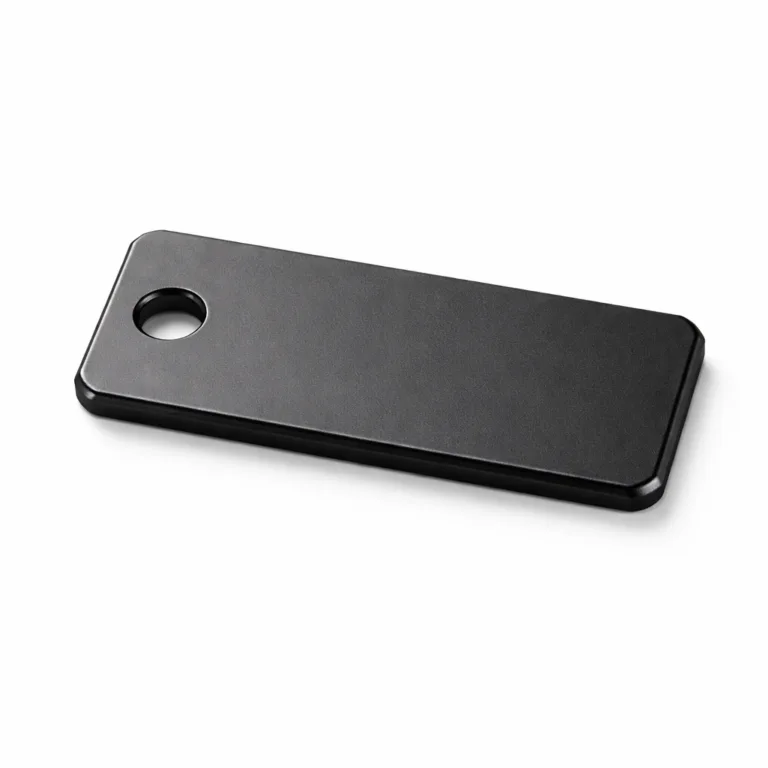 A modern size mark garment tag manufactured from anodized aluminum in a matte black finish. The tag has beveled edges for a refined look, with a single sewing hole positioned on the left for easy attachment to garments.