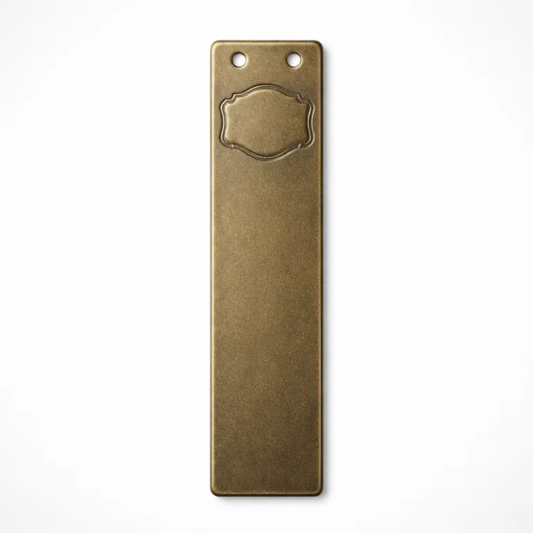 A slim bookmark tag made from metal with an antique brass finish and sandblasted matte texture. The design features two small holes at the top for versatile attachment and a blank debossed emblem, highlighting a vintage look suitable for classic styles.