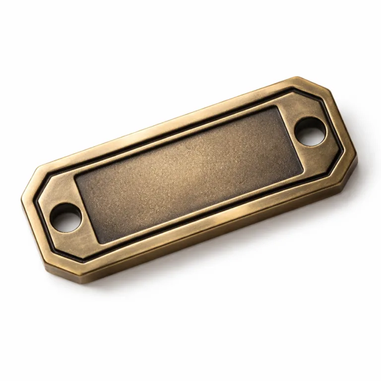 An elegant antique brass logo tag with a sandblasted matte texture, chamfered edge, and a recessed blank emblem. Features two holes suitable for sewing onto fabric products.