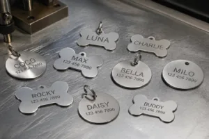 A detailed view of assorted stainless steel dog tags—bone and classic shapes—engraved and awaiting inspection. The metallic brilliance demonstrates the durability and premium quality of custom stainless steel pet tags.