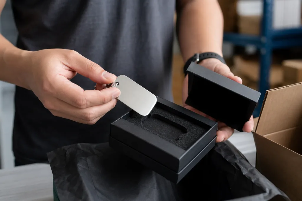 Unlock Memorable Unboxing: How Metal Tags Drive Customer Engagement & Brand Loyalty 1 A cinematic shot of a customer opening a package, focusing on the shiny metal tag inside. The lighting emphasizes tactile and visual appeal, reflecting the importance of brand identity.