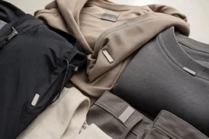 A studio scene showing apparel with different attached metal tags, highlighting the variety of constructions that affect wash and dryer performance.